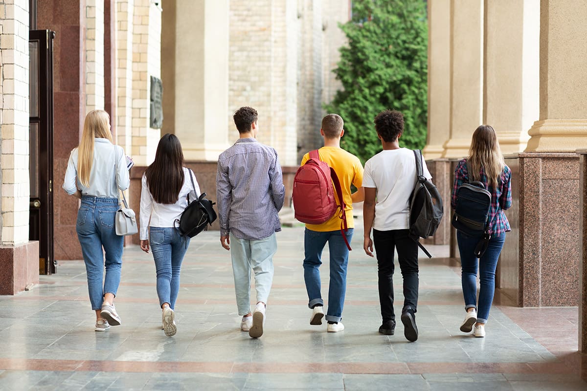 Six students with their backs turned walking way