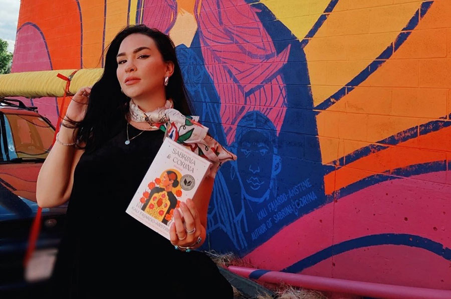 Kali-Fajardo-Anstine stands next to a mural created by Kaitlin Orin and Adam Raiola, at Nopalito's in Boulder Colorado.