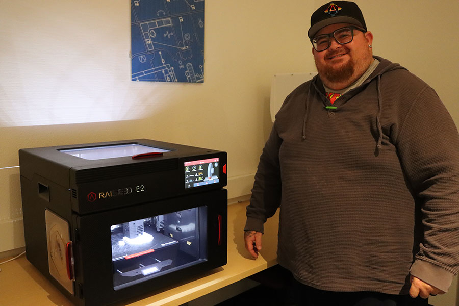 Drafting student, Romie Rousseau, with one of many cutting-edge 3D printers grant funded by Los Alamos National Laboratory.
