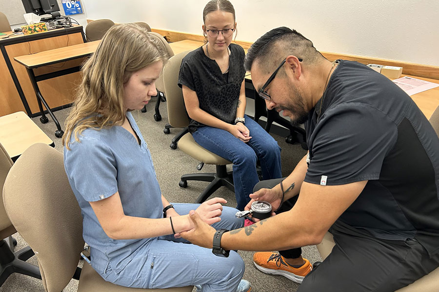 Joaquin Betoni and Nikole Busby test pinch strength of dental hygiene student Maddie Abernathy