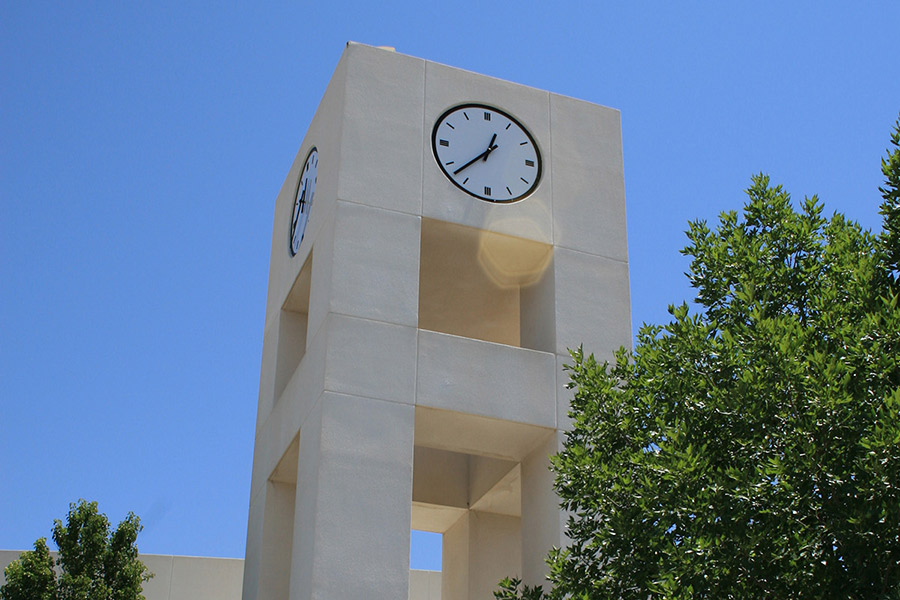 Top of the clocktower against a bright blue sky.