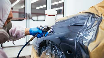 Person painting a car.