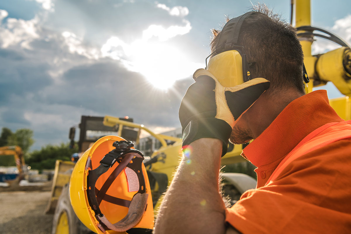 A San Juan College student putting on a hard hat while standing on a construction site