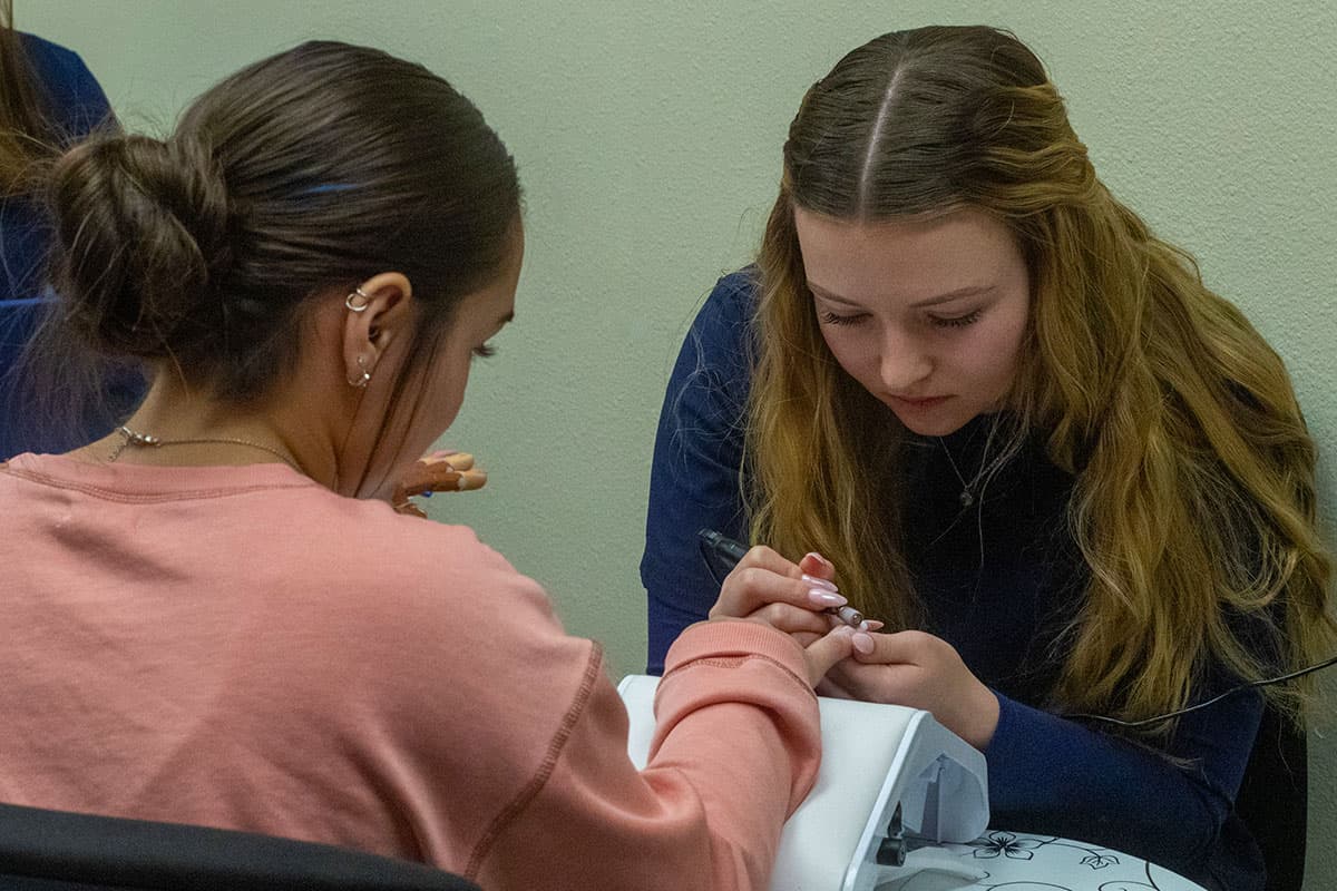 A San Juan College student giving a manicure