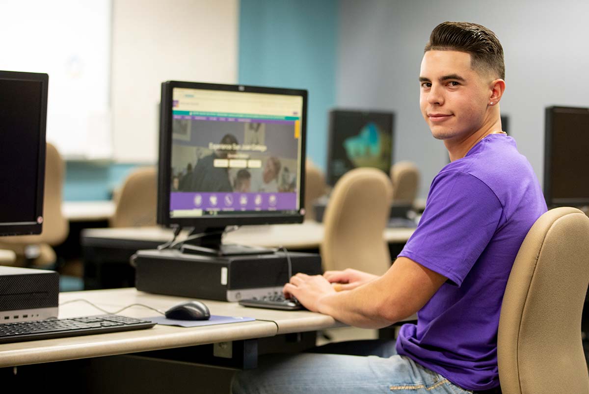 San Juan College IT student sitting in Computer Lab.