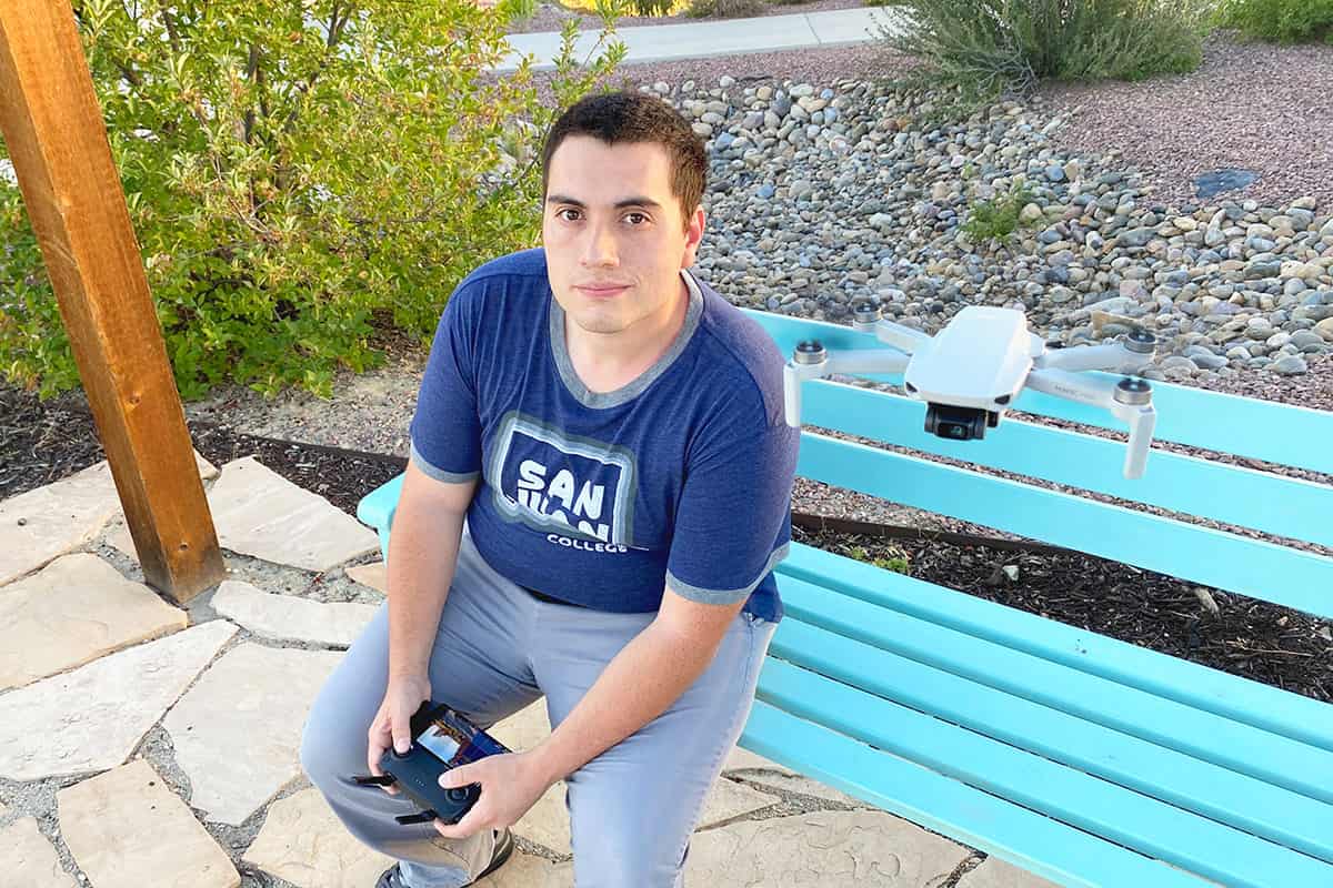 SUAS program graduate Josh Bishop operates a drone in outdoor space.