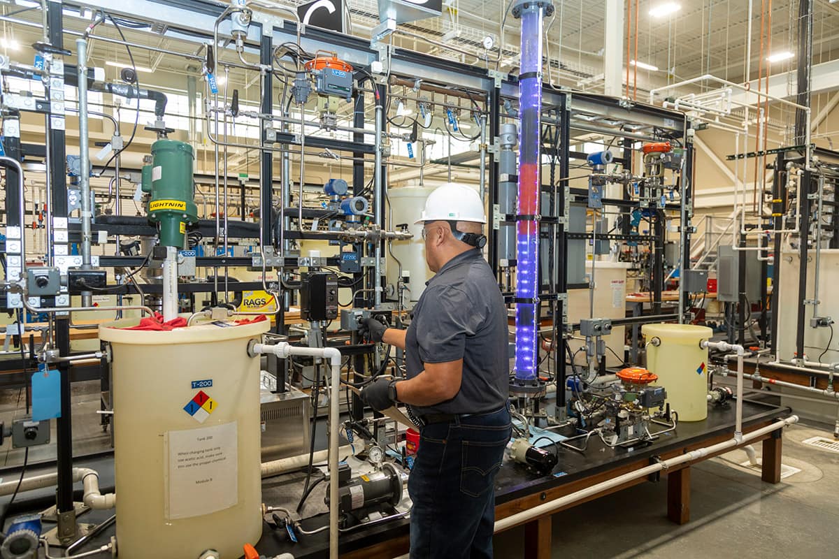 Water Treatment student adjust setting on training equipment in the program's lab facility.