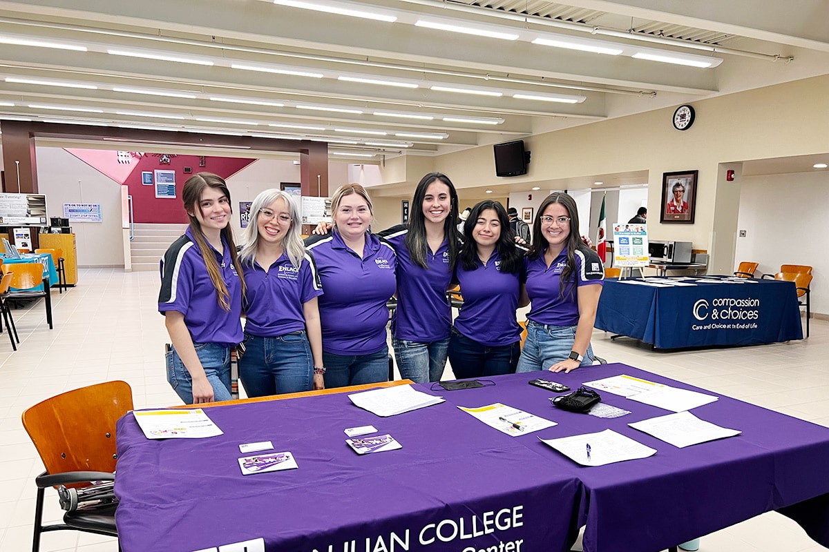 Students from the Herencia Latina Center man a help desk table in Mary's Kitchen