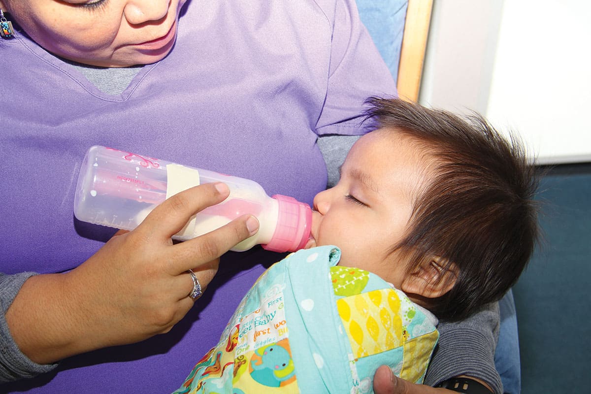 A student mother feeding her baby in one of SJC's lactation and family rooms